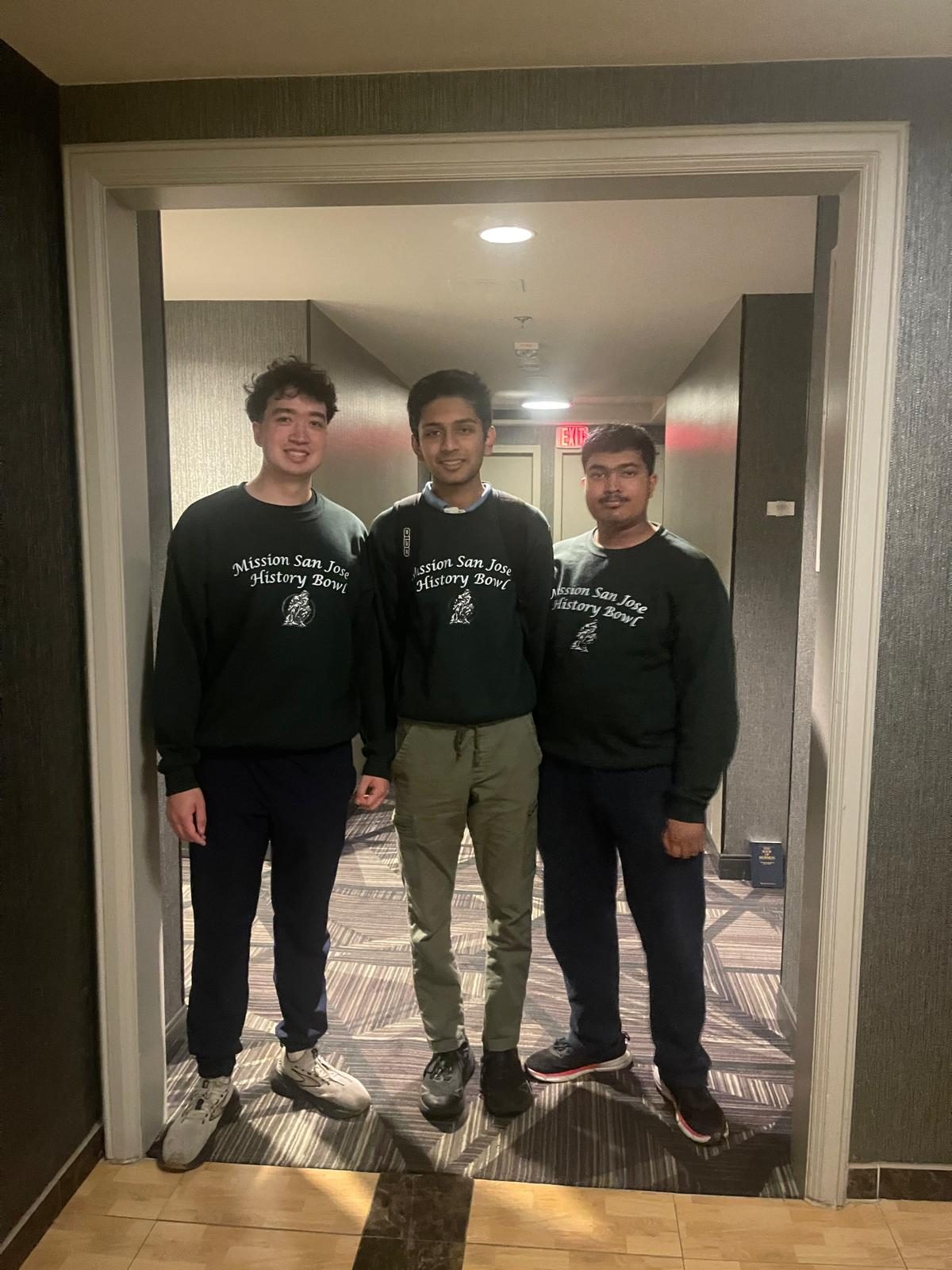 Three team members in Mission San Jose History Bowl sweatshirts in a hotel hallway